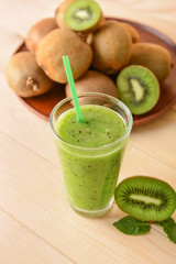 Glass of tasty kiwi smoothie on table