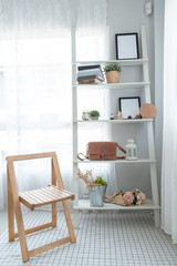 Interior white minimalist style with a wooden chair and a wooden shelf in living room .Decoration modern lifestyle concept