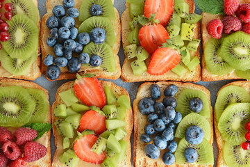 Tasty sandwiches with kiwi and berries, top view