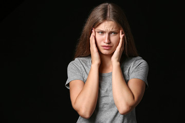 Stressed young woman on dark background