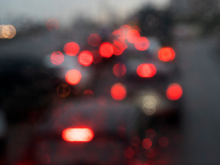 Out of focus image of cars standing in traffic jam in the rain