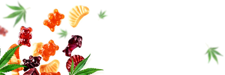 Colored gummies fly along with cannabis leaves. Chewing candies with CBD oil, THC. Background,...