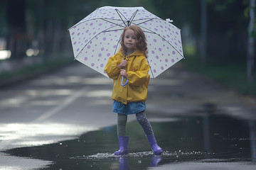 little girl with an umbrella / small child, rainy autumn walk, wet weather child with an umbrella