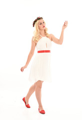 full length portrait of blonde girl wearing a white dress and flower crown.  Standing pose, isolated against a  white studio background.
