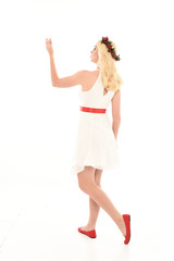 full length portrait of blonde girl wearing a white dress and flower crown.  Standing pose, isolated against a  white studio background.