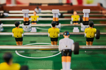 Table football, table football with close-ups of yellow and white players.