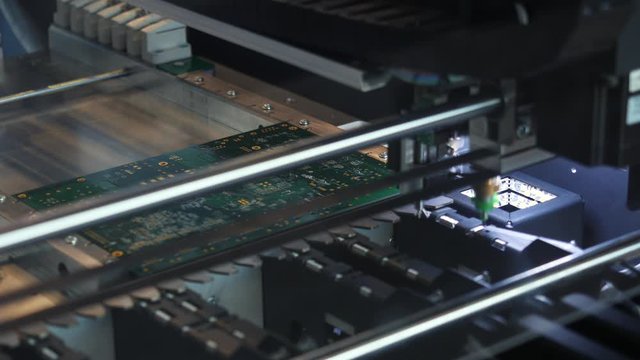 Close-up of printed circuit board which is created by special automatic machine in a workshop. Media. Electronics and technology concepts.