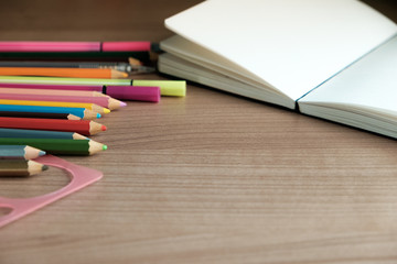 Obraz premium school supplies on wooden background,notebook,pencil ,coloured pencils,copy space.RAF