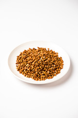 buckwheat in a saucer, on a white background