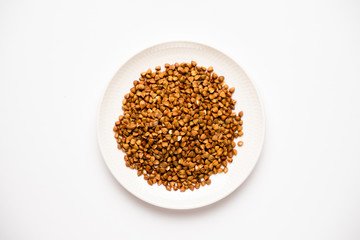 buckwheat in a saucer, on a white background