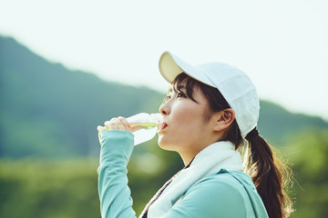 運動の合間に水分補給をする女性