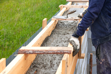 Worker levels concrete in formwork using a trowel