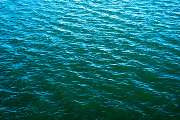 Obraz premium Ocean waves of sea with deep blue color water surface with natural light sunset of the sun with dramatic yellow and orange sky. Summer vacation or holiday relax concept.