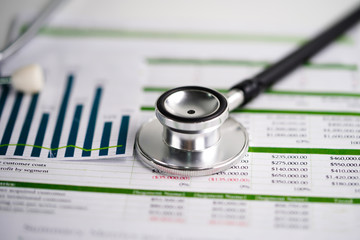 Stethoscope  on spreadsheet paper, Financial, account, statistics and business data  medical health concept.