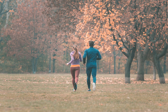 Fall Running In A Park, Seen From Behind Couple