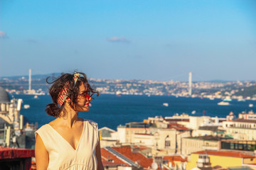 Fototapeta na wymiar Eurasian woman standing at the roof with bosphorus background in Istanbul, Turkey