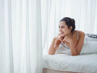 asian woman lying in white bed,relax in home