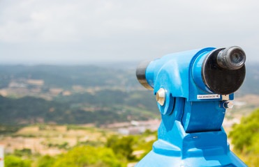 Tower viewer or tourist telescope with magnificent views and space for copy on the left.