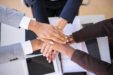 Business team showing unity with putting hands together. Businesspeople joining hands together....