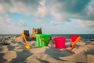 kids toys and sandcastle on tropical beach