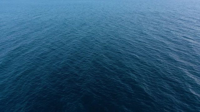 Flying over the blue surface of the sea or ocean
