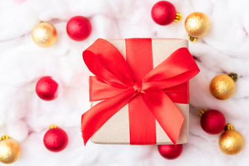 Christmas toys and gift with red ribbon, white snow from cotton wool. Winter holidays concept
