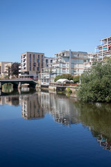Modern residential buildings in Leipzig scene district Schleussig directly on the river Elster with...