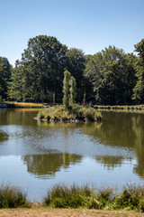 Fototapeta na wymiar View of an idyllic park landscape in Leipzig,Germany with a pond with island