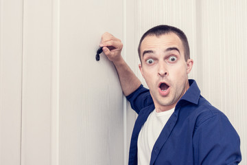 Amazing guy next to front door, man looked through the peephole of the front door, portrait, close up, toned