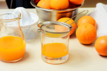 Young woman making juice with fresh oranges with manual juicer. Healthy lifestyle.