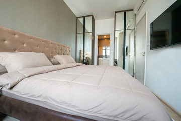 Fototapeta na wymiar Bright and cozy modern bedroom with dressing room