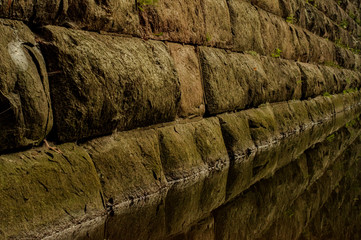 Ancient stone wall whose base is flooded with water