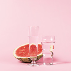 Half of watermelon and glasses with water