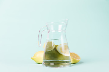 Lemons and jug on blue background
