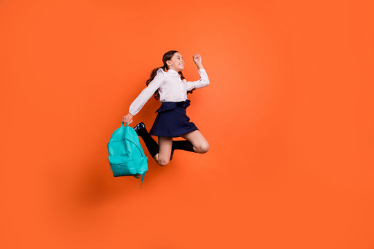 Full length body size profile side view photo cute sweet kid rejoice movement dreamy lesson break pause dress white blouse she her boots trendy stylish pigtails ponytails isolated orange background