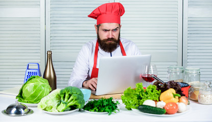 Man chef searching internet recipe cooking food. Chef laptop read culinary recipes. Culinary...
