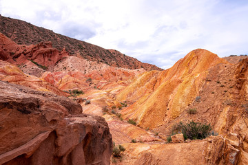 Multicolor mountains in the gorge Fairy Tale against the background of a cloudy sky.