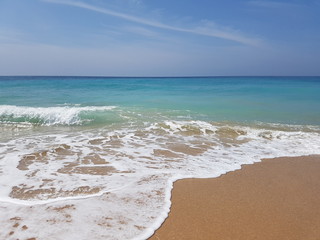 Deserted paradise beach with foamy waves