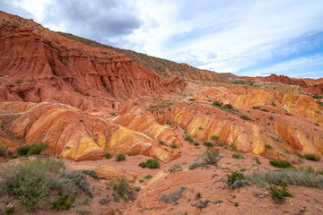 Multicolor mountains in the gorge Fairy Tale against the background of a cloudy sky. Tourism Kyrgyzstan