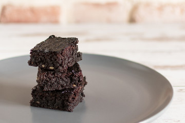 A stack of chocolate brownies on wooden background, homemade bakery and dessert.