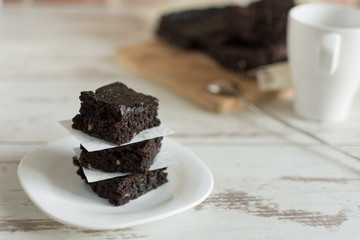 A stack of chocolate brownies on wooden background, homemade bakery and dessert.