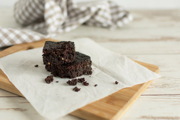 A stack of chocolate brownies on wooden background, homemade bakery and dessert.