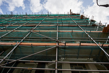 Professional scaffolding on the side of a building under renovation.