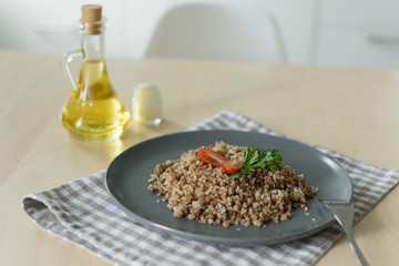 Buckwheat porridge with tomato and parsley. Olive oil and sour cream for dressing.