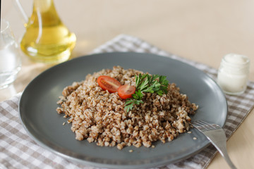 Buckwheat porridge with tomato and parsley. Olive oil and sour cream for dressing.