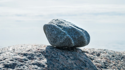Minimalistic stone arrangement at the beach in shades of blue 