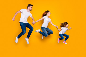 Fototapeta na wymiar Full length body size view of three nice attractive sporty cheerful funny funky person active activity motion holding hands sale discount hurry rush isolated over bright vivid shine yellow background