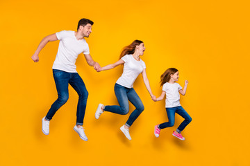 Fototapeta na wymiar Full length body size view of three nice attractive slim sporty cheery funny person active activity motion fast movement holding hands sale discount isolated over bright vivid shine yellow background
