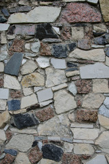 Wall of granite stones of different colors.