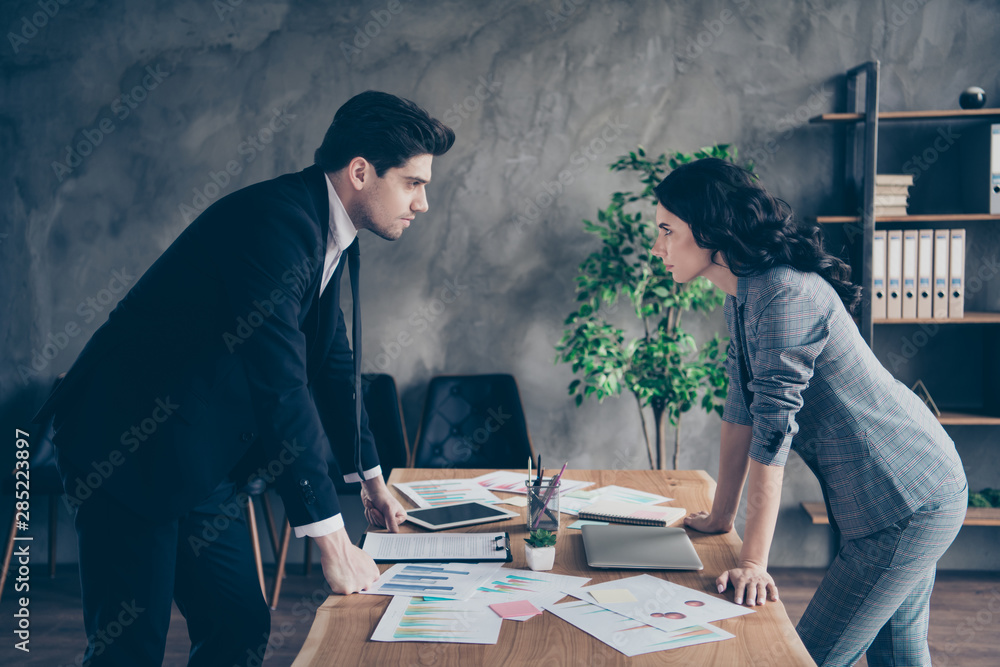 Sticker Photo of two partners seriously looking eyes competitive report standing near table workshop table